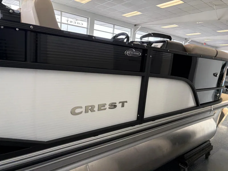 Slide: The Image of 2025 Crest 220 SLSC pontoon boat in showroom, side view. - 2
