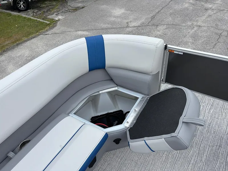 Slide: The Image of 2025 SunCatcher Select 322RF boat interior with open storage compartment and cushioned seating. - 13