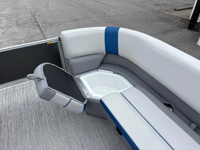 Slide: The Image of 2025 SunCatcher Select 322RF boat interior with gray and blue cushioned seating and storage compartment. - 16