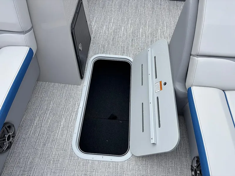 Slide: The Image of Open storage compartment on 2025 SunCatcher Select 322RF boat with gray and blue seating. - 19