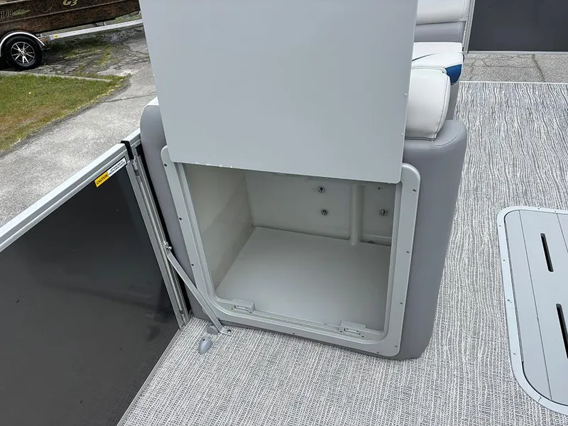 Slide: The Image of Open storage compartment on 2025 SunCatcher Select 322RF boat, featuring gray upholstery and textured flooring. - 23