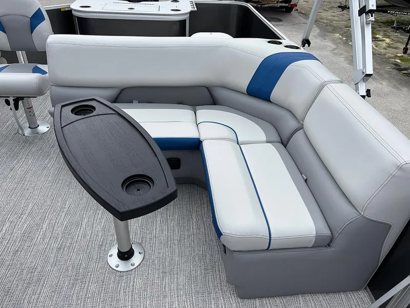 Slide: The Image of 2025 SunCatcher Select 322RF boat interior with gray and blue seating and a black table. - 25