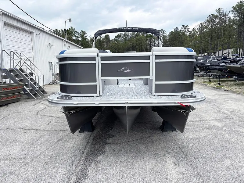 Slide: The Image of 2025 SunCatcher Select 322RF pontoon boat parked outdoors near a warehouse. - 4