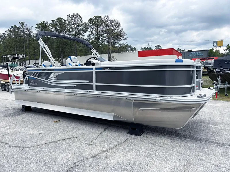 Slide: The Image of 2025 SunCatcher Select 322RF pontoon boat parked outdoors on a cloudy day. - 5