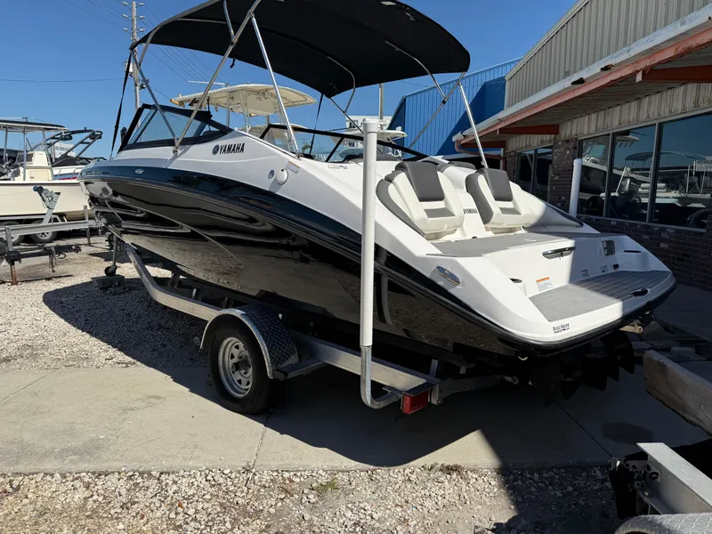Slide: The Image of 2022 Yamaha SX210 boat on trailer, black and white design, parked outdoors. - 3