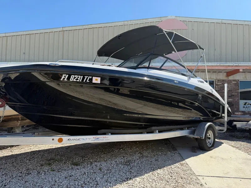 Slide: The Image of 2022 Yamaha Boats SX210 on trailer, black hull, parked outdoors. - 4