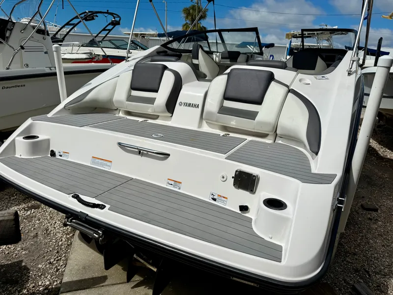 Slide: The Image of 2022 Yamaha SX210 boat with sleek design and comfortable seating, docked under a clear blue sky. - 5