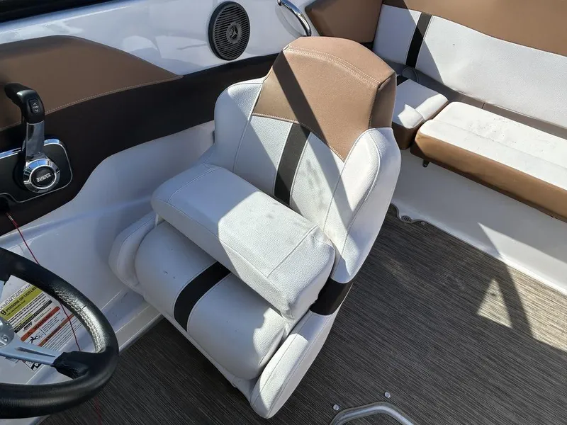 Slide: The Image of Captain's seat in 2017 Four Winns Horizon 190 boat, featuring brown and white upholstery. - 10