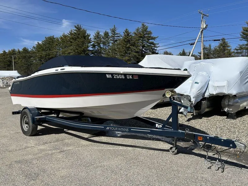 Slide: The Image of 2017 Four Winns Horizon 190 boat on trailer, parked outdoors, under clear blue sky. - 2
