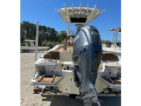 Slide: The Image of 2025 Pioneer 202 Islander boat with powerful outboard motor, parked outdoors. - 2