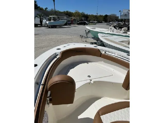 Slide: The Image of 2025 Pioneer 202 Islander boat interior with tan seating, docked outdoors. - 3