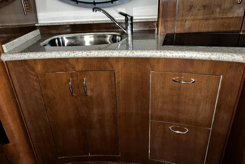 Slide: The Image of 2008 Carver 36 Mariner kitchen with wood cabinets, stainless steel sink, and modern faucet. - 11