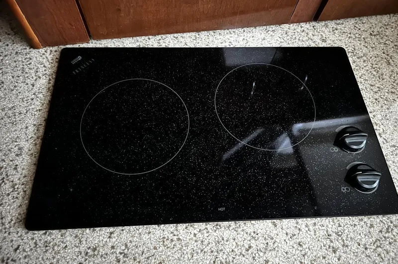 Slide: The Image of Black glass cooktop with two burners and control knobs, inside a 2008 Carver 36 Mariner. - 12