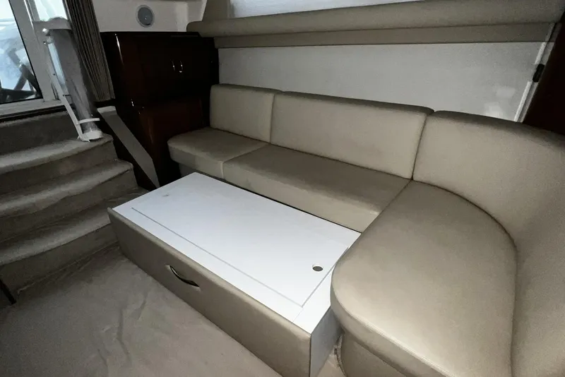 Slide: The Image of Interior of 2008 Carver 36 Mariner with beige seating and storage table. - 17