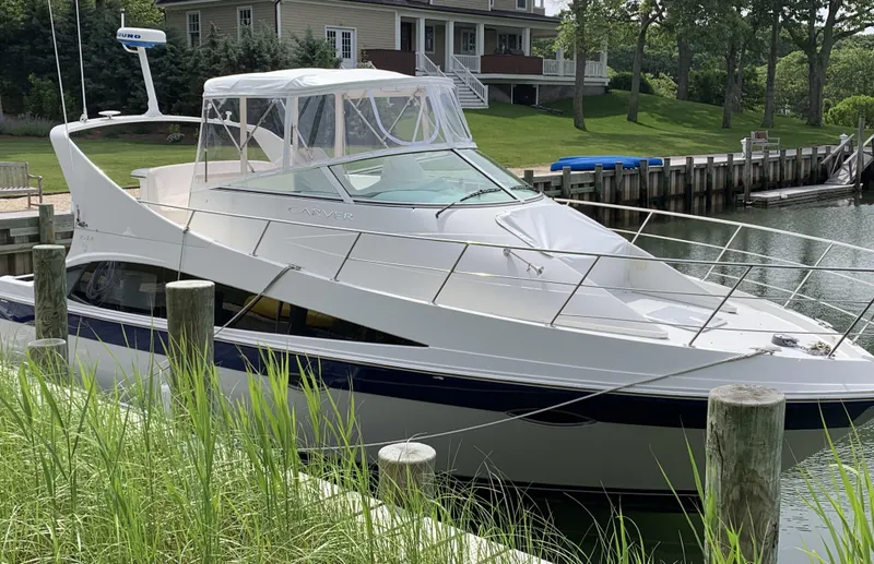 Slide: The Image of 2008 Carver 36 Mariner yacht docked near waterfront home. - 2