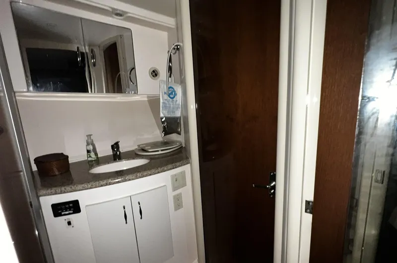 Slide: The Image of 2008 Carver 36 Mariner bathroom with sink, mirror, and wooden door. - 21