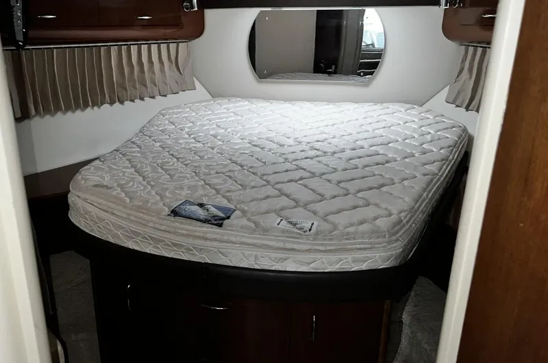 Slide: The Image of 2008 Carver 36 Mariner cabin with a neatly made bed and round mirror. - 22