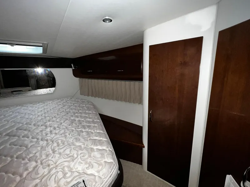 Slide: The Image of 2008 Carver 36 Mariner bedroom with mattress, wooden cabinets, and window. - 24