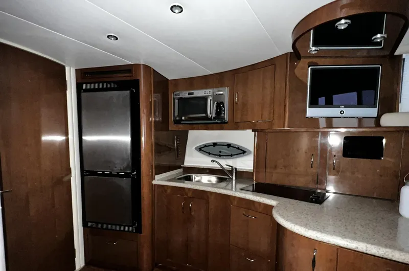 Slide: The Image of Interior of 2008 Carver 36 Mariner yacht kitchen with modern appliances and wood cabinetry. - 29