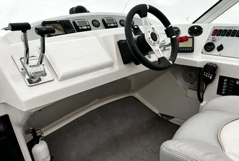 Slide: The Image of 2008 Carver 36 Mariner helm with steering wheel, controls, and navigation instruments. - 37