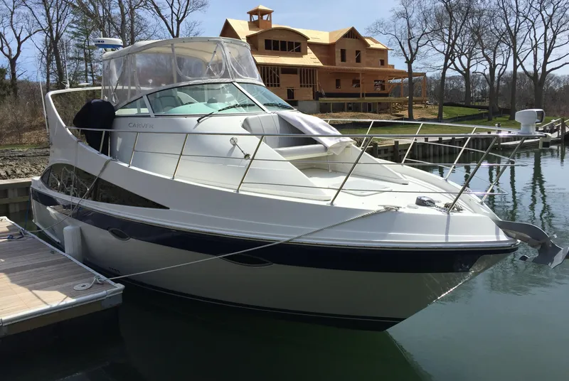 Slide: The Image of 2008 Carver 36 Mariner yacht docked near a waterfront house. - 4
