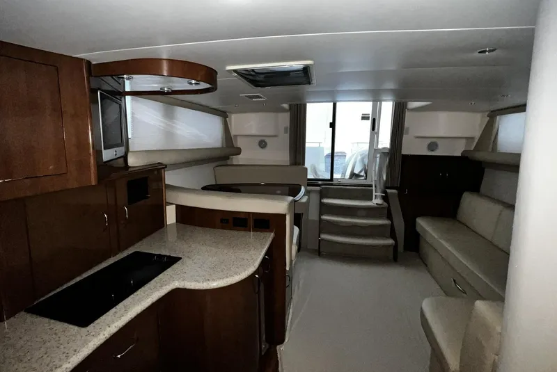 Slide: The Image of Interior of 2008 Carver 36 Mariner yacht, featuring kitchen and seating area. - 8