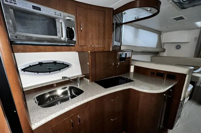 Slide: The Image of 2008 Carver 36 Mariner yacht interior with kitchenette, microwave, sink, and seating area. - 9