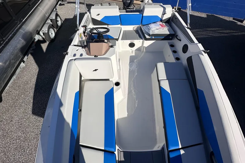 Slide: The Image of 2025 Starcraft SV 16 OB boat with blue and white seating, steering wheel, and storage compartments. - 2