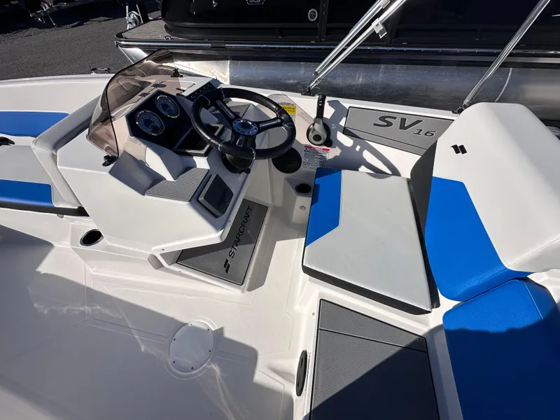 Slide: The Image of 2025 Starcraft SV 16 OB boat interior with steering wheel and blue seating. - 3