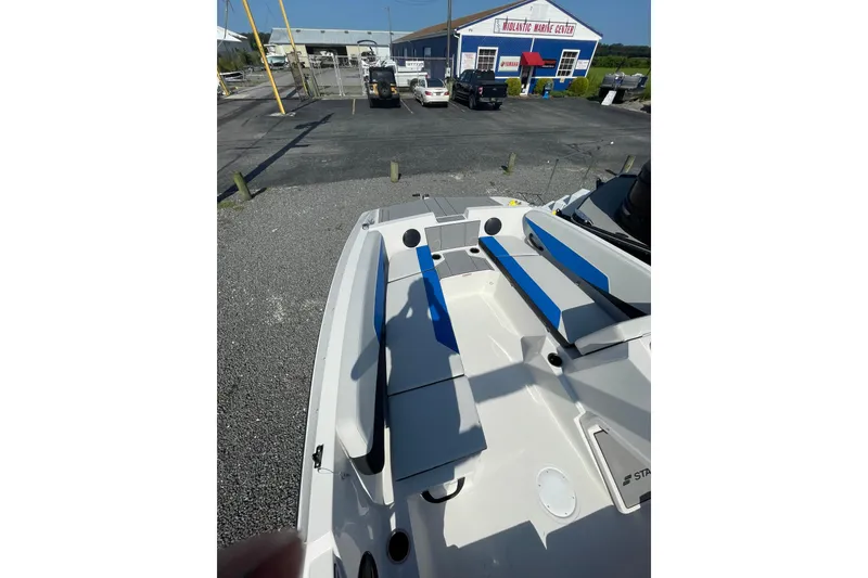 Slide: The Image of 2025 Starcraft SV 16 OB boat with blue seating, parked at a marine center. - 9
