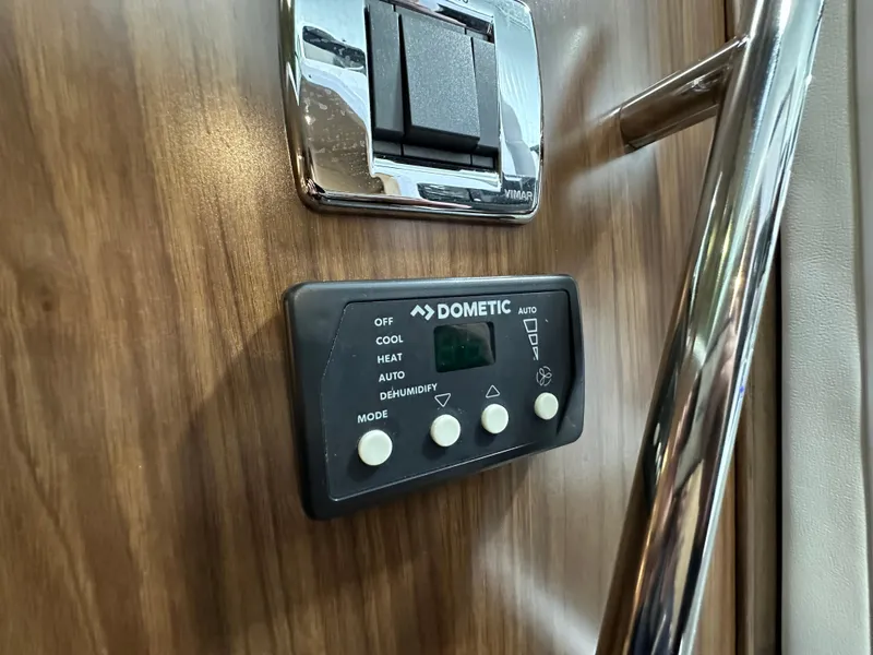 Slide: The Image of Dometic control panel on 2021 Four Winns Vista 275 boat interior, wood finish background. - 19