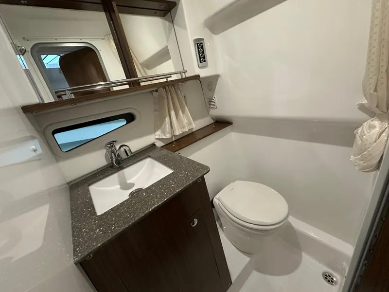Slide: The Image of 2021 Four Winns Vista 275 bathroom with sink, toilet, and mirror. - 21