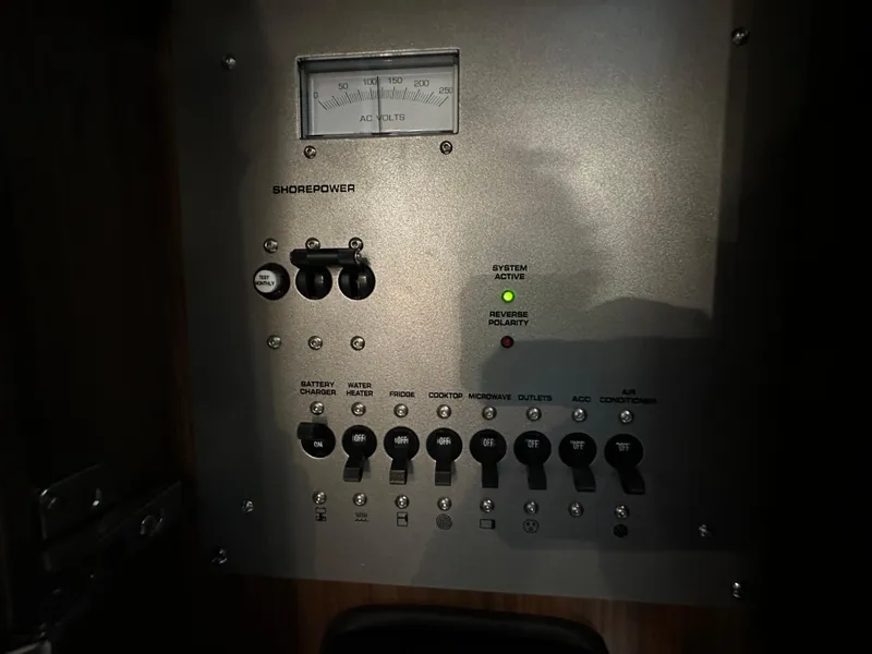 Slide: The Image of Control panel of a 2021 Four Winns Vista 275 boat, featuring shore power and system status indicators. - 22