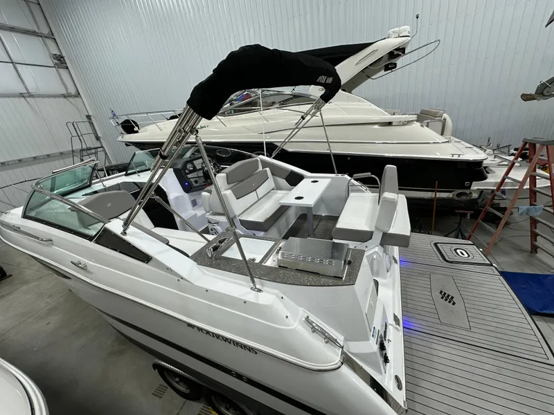 Slide: The Image of 2021 Four Winns Vista 275 boat in a storage facility, showcasing sleek design and spacious seating. - 3