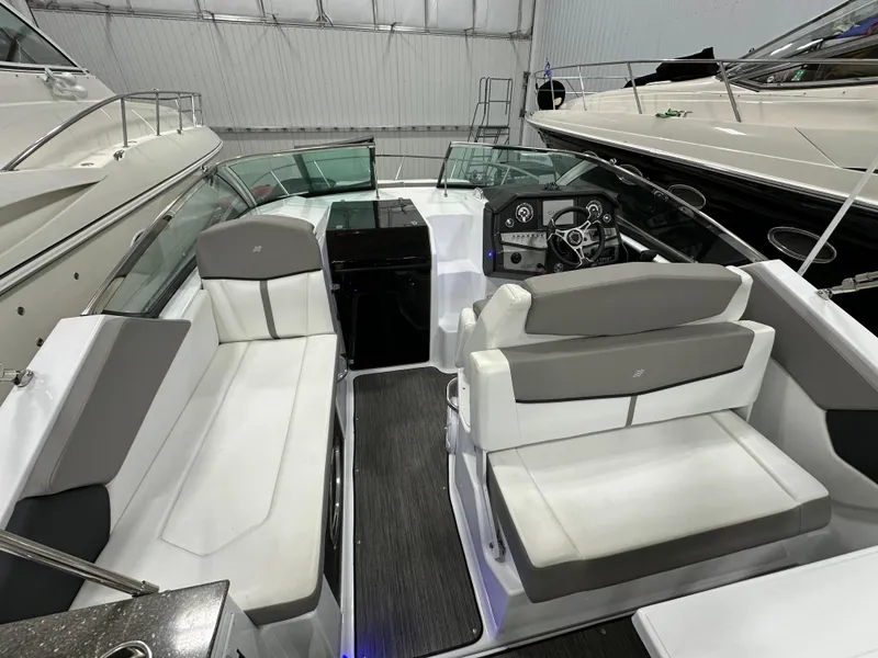 Slide: The Image of 2021 Four Winns Vista 275 boat interior with seating and control panel in a showroom. - 9