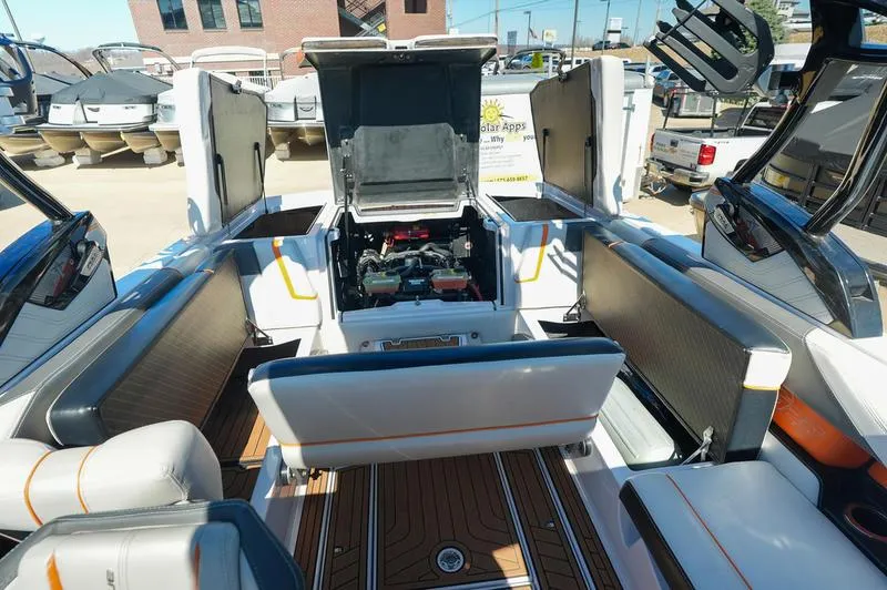 Slide: The Image of 2015 Nautique Super Air G23 boat interior with open engine compartment, showcasing seating and deck. - 11