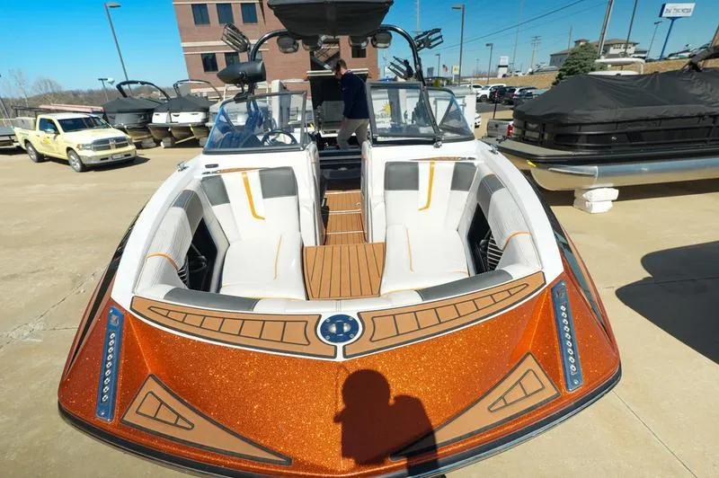 Slide: The Image of 2015 Nautique Super Air G23 boat with orange detailing, parked outdoors. - 16