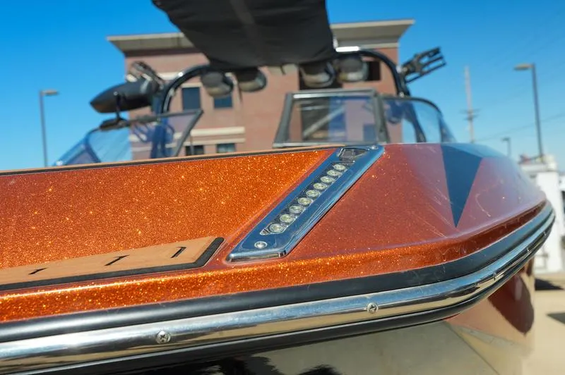 Slide: The Image of 2015 Nautique Super Air G23 boat with metallic orange finish and sleek design. - 17