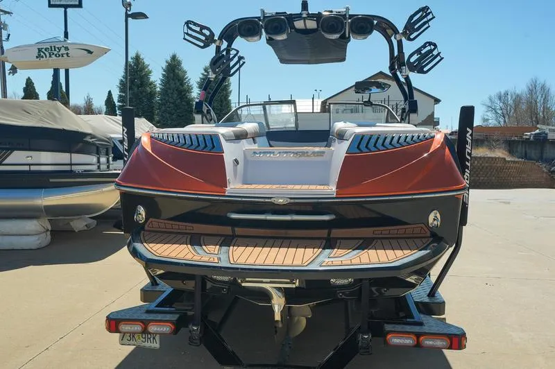 Slide: The Image of 2015 Nautique Super Air G23 boat, rear view, parked outdoors on a sunny day. - 24