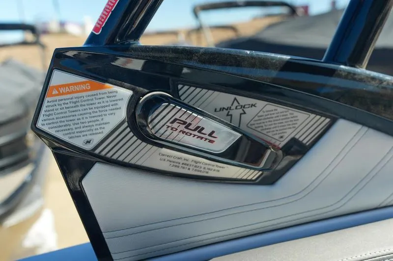 Slide: The Image of 2015 Nautique Super Air G23 boat handle with warning label and unlock mechanism. - 25