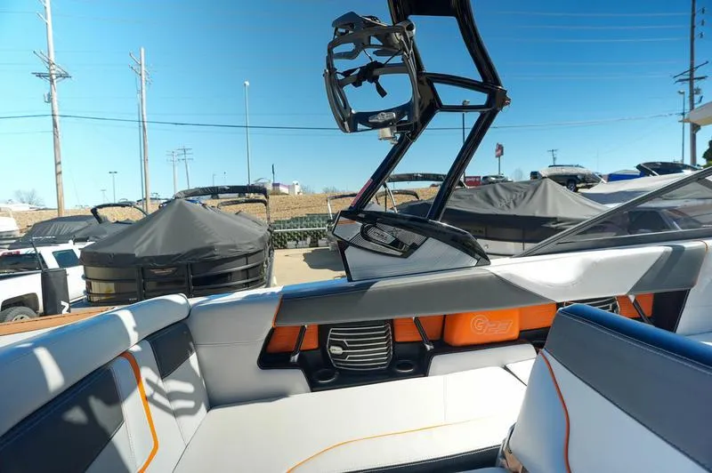 Slide: The Image of 2015 Nautique Super Air G23 interior with wakeboard tower, orange accents, and seating. - 26