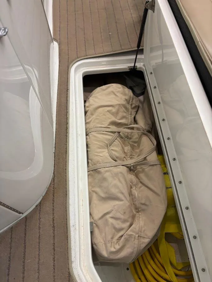 Slide: The Image of Storage compartment in a 2012 Formula 290 Bowrider boat with beige cover and yellow rope. - 21