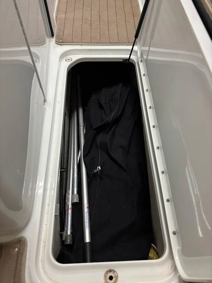 Slide: The Image of Storage compartment in a 2012 Formula 290 Bowrider boat, containing poles and fabric. - 24
