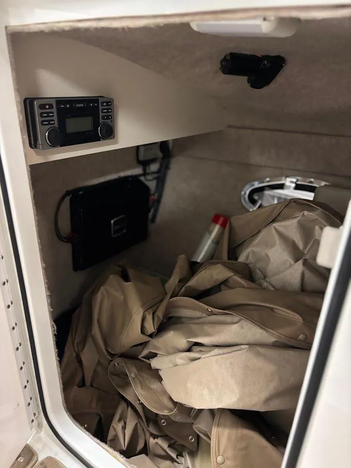 Slide: The Image of 2012 Formula 290 Bowrider storage compartment with electronics and beige cover. - 25