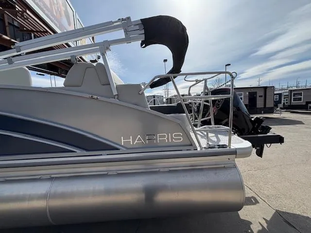 Slide: The Image of 2025 Harris Cruiser 210 SLDH pontoon boat, silver exterior, docked outdoors under a clear sky. - 29