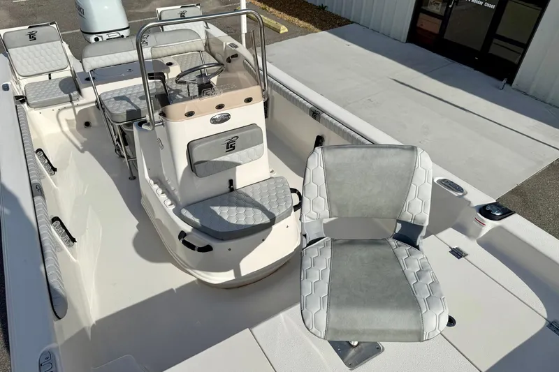 Slide: The Image of 2025 Carolina Skiff 19 LS boat interior with seating and console, docked outdoors. - 12