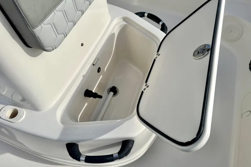Slide: The Image of 2025 Carolina Skiff 19 LS boat storage compartment with open lid and handle. - 15