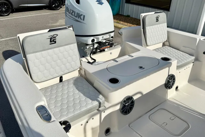 Slide: The Image of 2025 Carolina Skiff 19 LS boat interior with Suzuki engine, featuring cushioned seating and storage. - 23