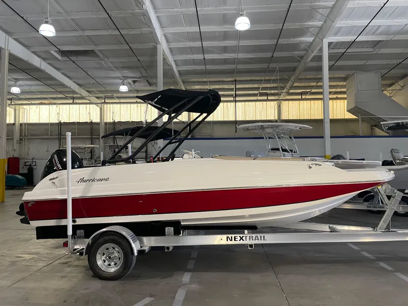 Slide: The Image of 2021 Hurricane SunDeck Sport 201 OB boat on trailer in indoor storage. - 1