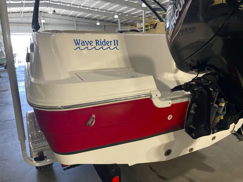Slide: The Image of 2021 Hurricane SunDeck Sport 201 OB boat, red and white, in a garage setting. - 10
